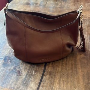 Michael Kors light brown purse with single strap.